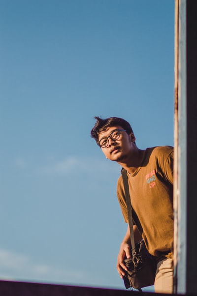 男人棕色背心站在棕色木质白天
